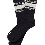Black socks with white checkered patterns on a beige background