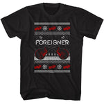 Black t-shirt featuring a knit-style Foreigner design with crossed red guitars, snowflakes, and holiday sweater patterns.