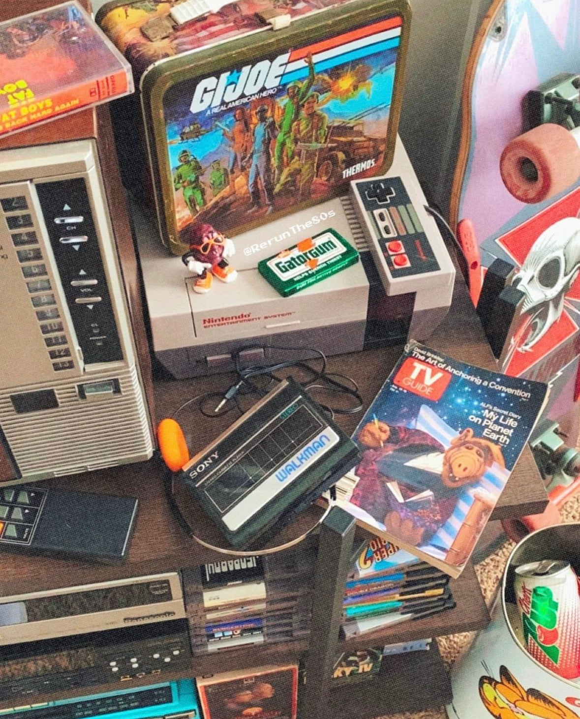 1980s memorabilia, including a metal GI Joe lunchbox, an issue of TV Guide with Alf on the cover, the Nintendo Entertainment System (NES), and a Sony Walkman