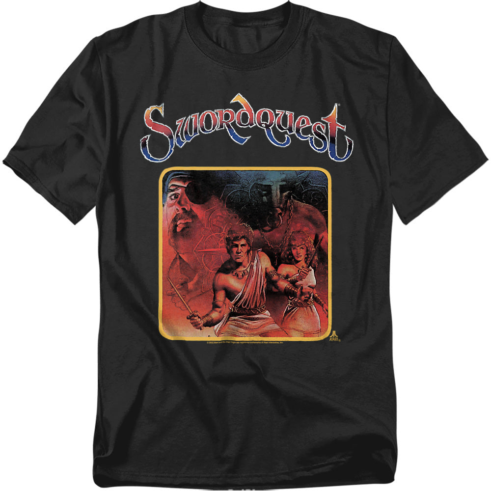 A black t-shirt featuring the Atari Swordquest artwork. The design shows a muscular hero and a woman with weapons, framed in a golden border, with a mysterious one-eyed figure and shadowy background behind them. The word “Swordquest” appears in a stylized fantasy font above the artwork.
