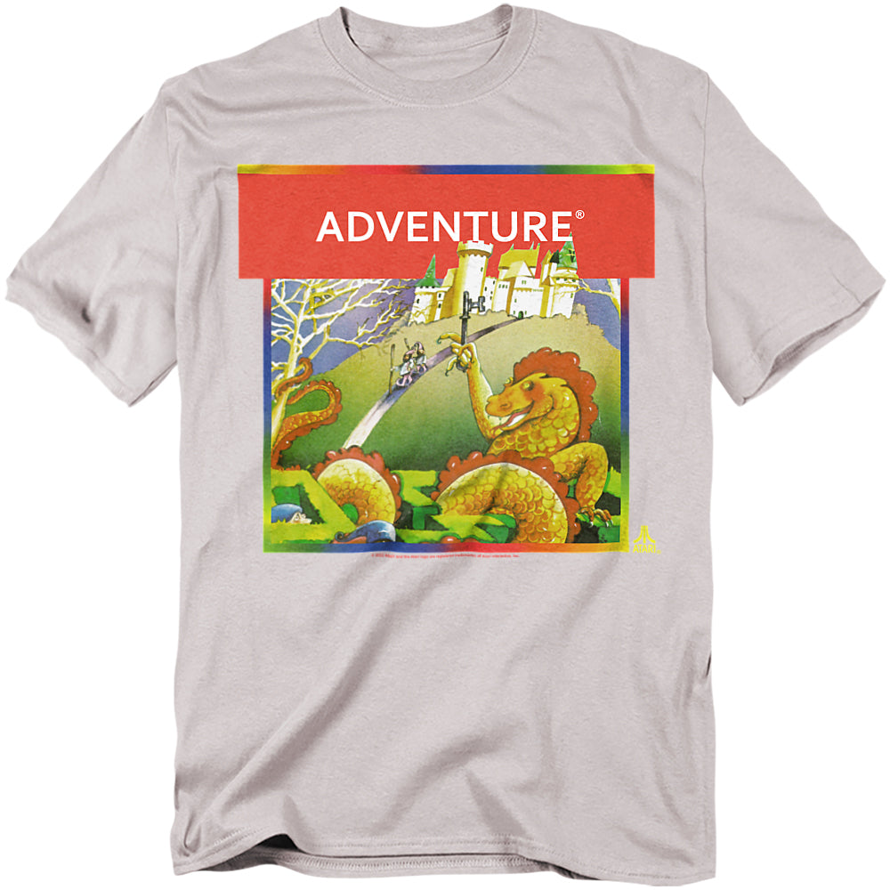 A light gray t-shirt featuring the classic Atari Adventure box art. The design shows a medieval knight confronting a dragon in front of a castle, framed by a bold red banner with the word “ADVENTURE” in white text.