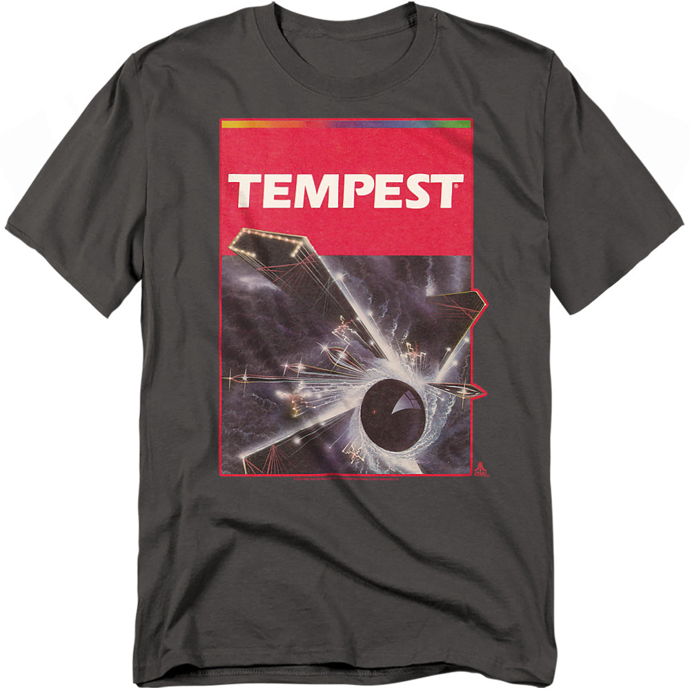A charcoal gray t-shirt featuring classic box art from Atari’s Tempest. The design shows a cosmic vortex pulling geometric enemies into a glowing center, framed by a red border with the bold white “TEMPEST” title.