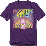 Purple Care Bears t-shirt with Cheer Bear swinging in front of a rainbow and the words “Positive Vibes.”