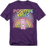 Purple Care Bears t-shirt with Cheer Bear swinging in front of a rainbow and the words “Positive Vibes.”