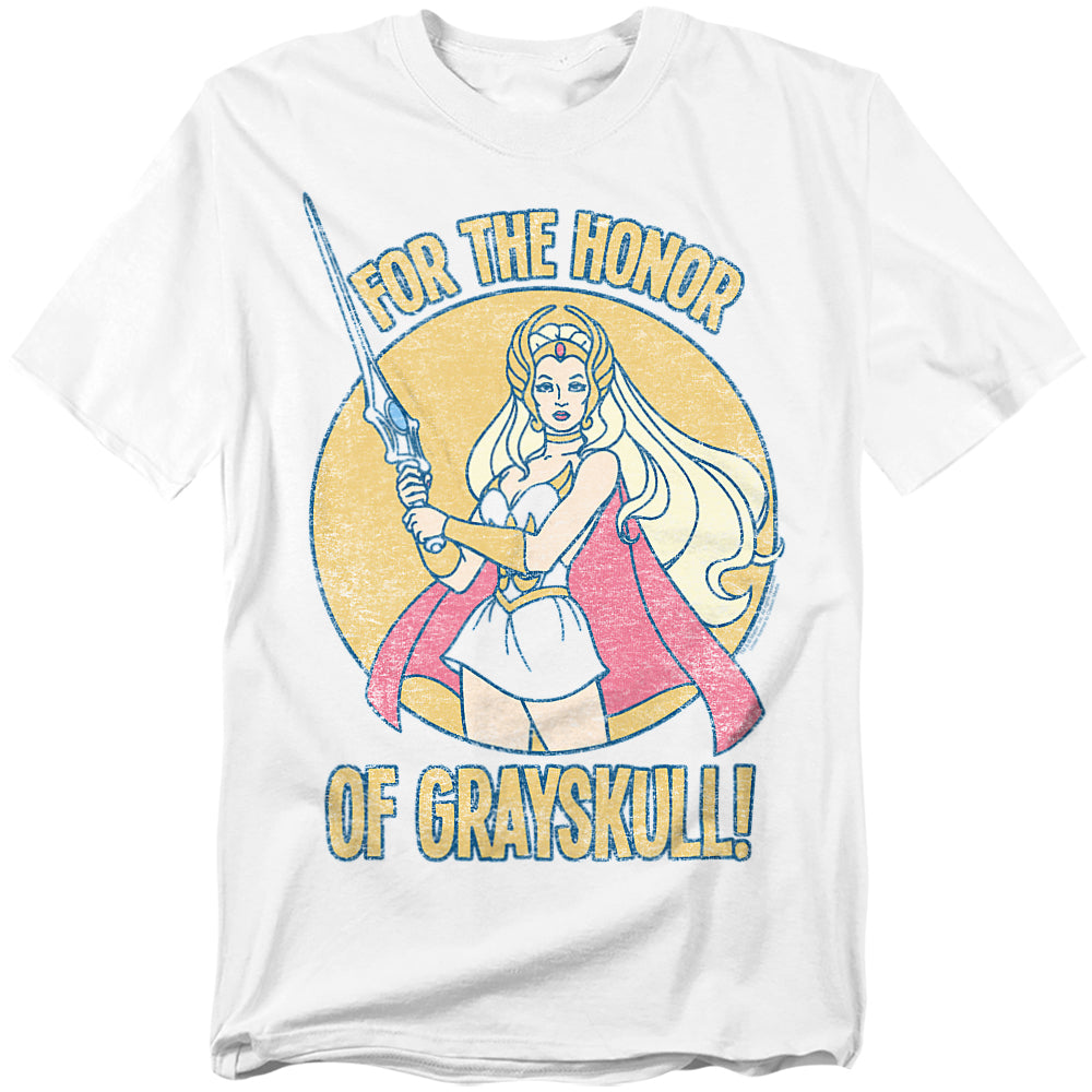 A white t-shirt featuring She-Ra holding her sword high with the phrase “For the Honor of Grayskull!” in bold distressed text. A large yellow circle frames her in the background, and she wears her classic outfit with a red cape.