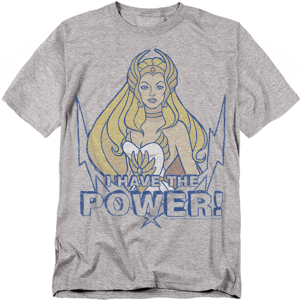 A gray t-shirt featuring She-Ra from She-Ra: Princess of Power. She is illustrated with long blonde hair, a white costume, and a golden tiara. Below her, bold distressed blue text reads “I HAVE THE POWER!” with lightning bolt graphics surrounding the design.