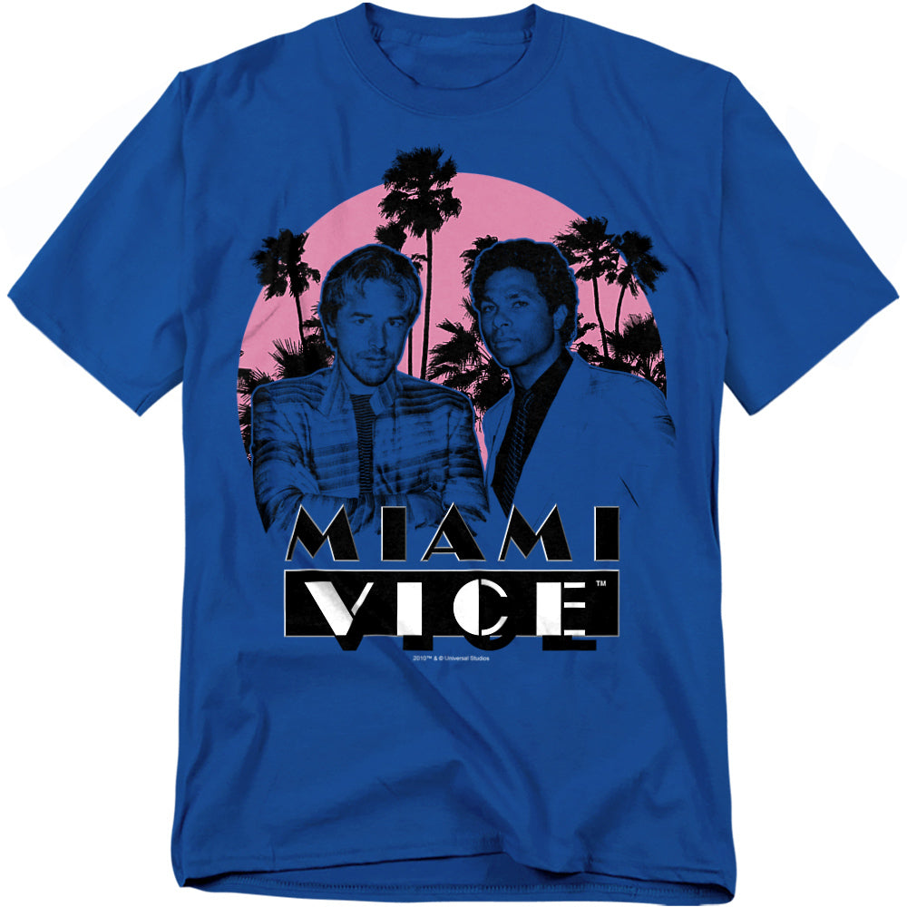 Blue t-shirt featuring Crockett and Tubbs from Miami Vice standing in front of palm trees and a neon pink sunset, with bold Miami Vice logo underneath.