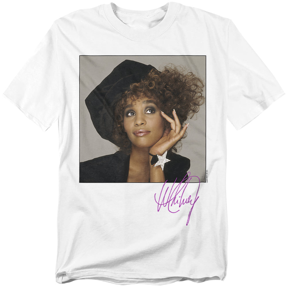 White t-shirt featuring a portrait of Whitney Houston in a stylish hat with her purple autograph printed below.