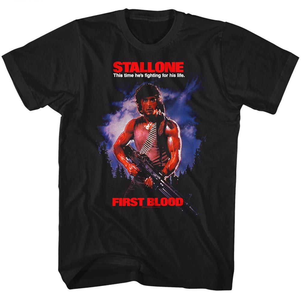 Black t-shirt featuring Sylvester Stallone as John Rambo in First Blood, holding a machine gun against a dramatic forest and storm backdrop with bold red “STALLONE” and “FIRST BLOOD” text.