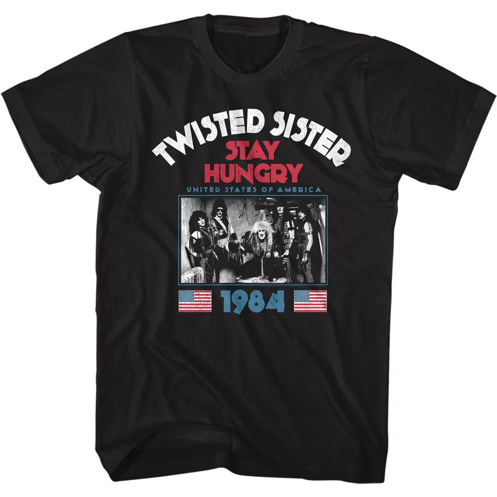 Black T-shirt featuring Twisted Sister “Stay Hungry” 1984 graphic with band photo, red lettering, and USA flag accents.