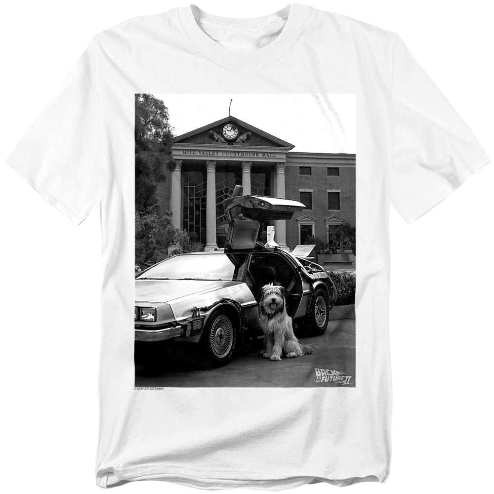 White t-shirt with a graphic of a dog standing next to a DeLorean car in front of a building.