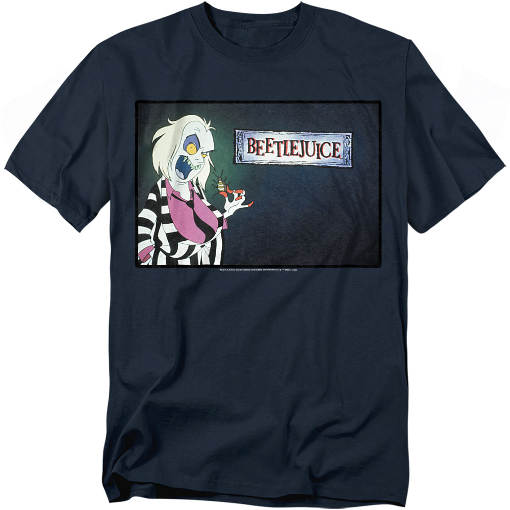 A navy blue t-shirt featuring Beetlejuice from the animated series. The design shows him with exaggerated facial features, sticking out his long green tongue while holding a small bug-like creature. He wears his iconic black-and-white striped suit with a purple shirt. The Beetlejuice logo is displayed to the right in a distressed frame.