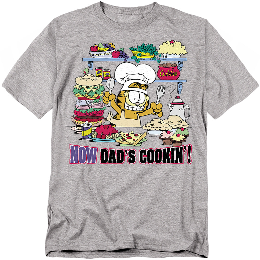 Garfield Now Dad’s Cookin’ T-shirt featuring Garfield cooking in a kitchen filled with food and desserts
