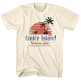 Cream-colored Jaws T-Shirt featuring a vintage Amity Island beach welcome sign with sunset, palm trees, and shark fin graphic