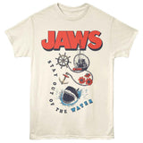 Cream-colored Jaws T-Shirt featuring the JAWS logo, shark graphic, Orca boat, anchor, ship wheel, flowers, and “Stay Out of the Water” text