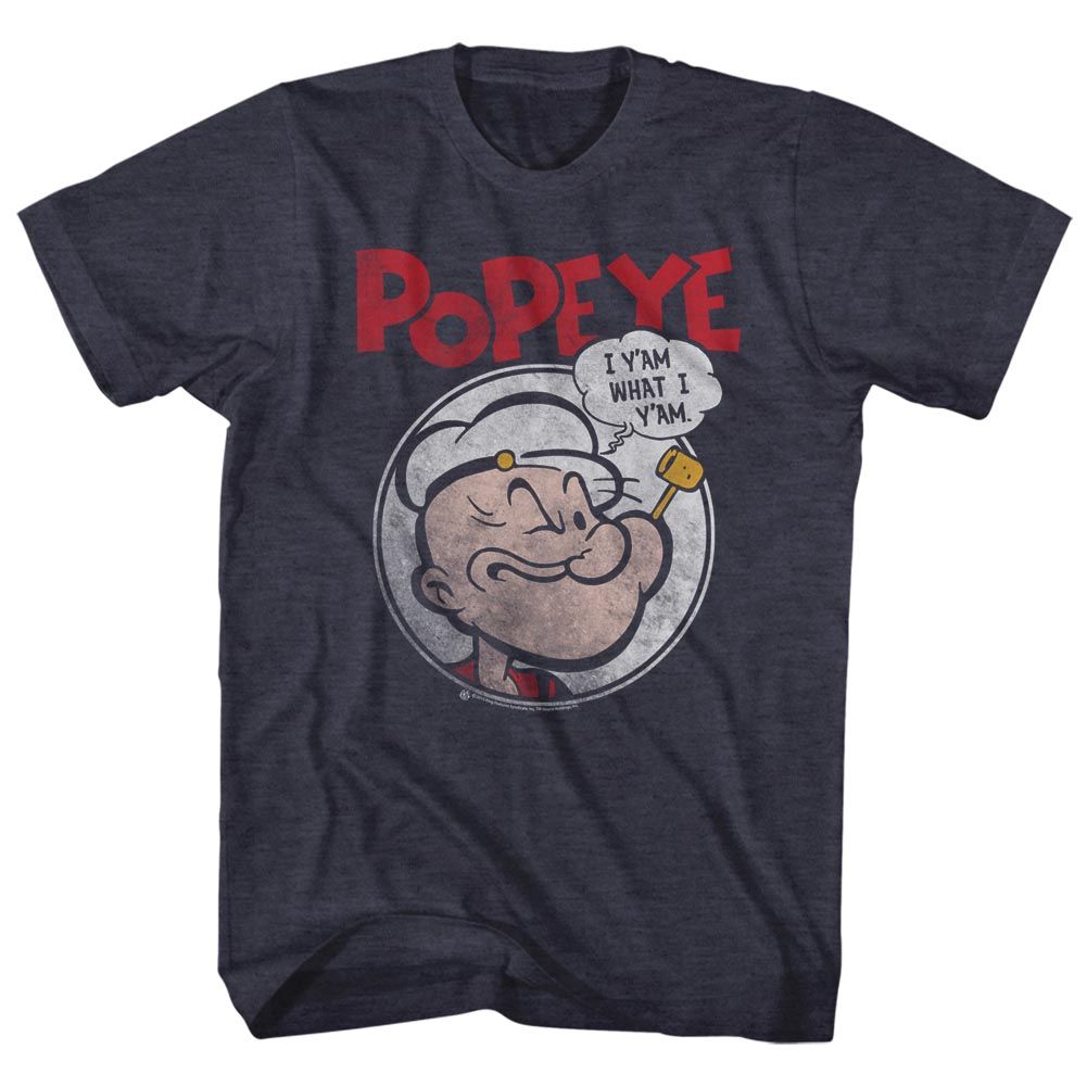 Heather navy T-shirt featuring a vintage-style illustration of Popeye inside a circular frame with a speech bubble saying “I y’am what I y’am” and bold red “POPEYE” text above.