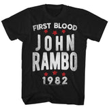 Black Rambo T-shirt with bold white lettering reading “First Blood John Rambo 1982” and red stars, celebrating the 1982 action film classic.