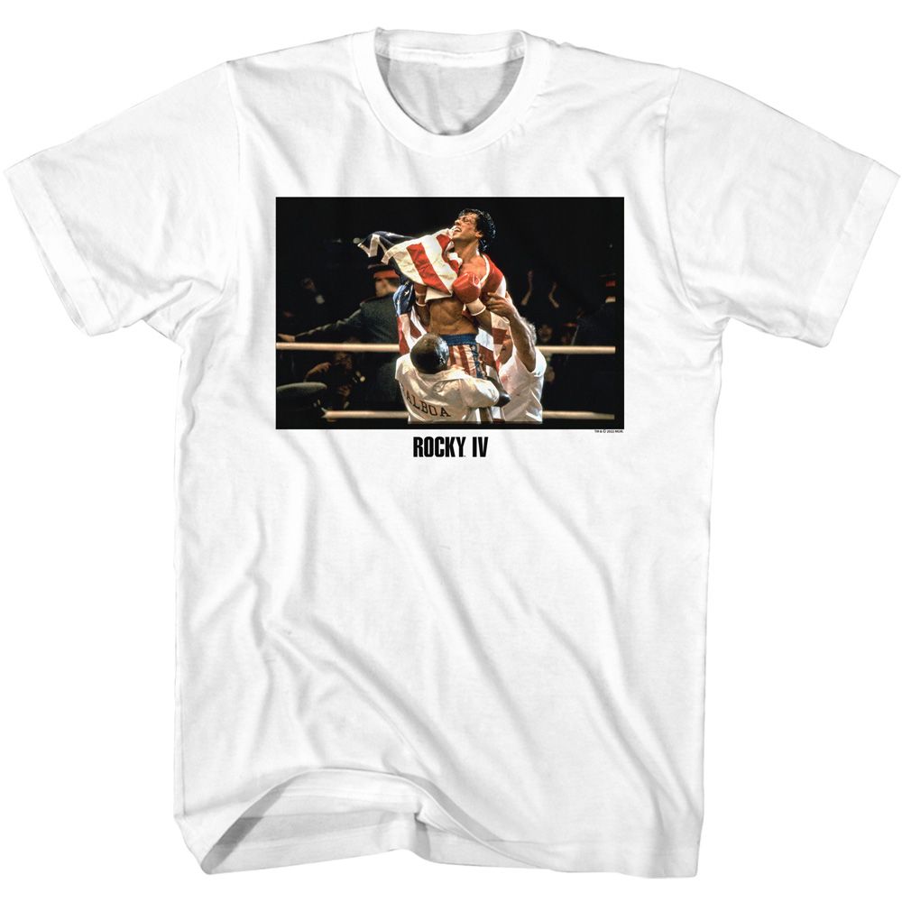 White Rocky IV T-shirt featuring Rocky Balboa celebrating victory in the ring wrapped in the American flag after defeating Ivan Drago.