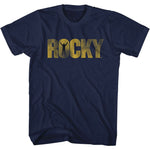 Navy blue T-shirt featuring the Rocky logo in gold lettering with a silhouette of Rocky Balboa raising his arms in victory.