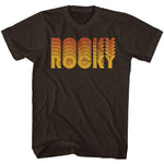 Brown T-shirt with a retro-style orange and yellow “Rocky” logo inspired by the 1976 boxing movie.