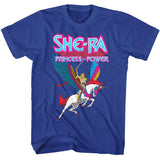 She-Ra Princess of Power graphic on a blue t-shirt showing She-Ra riding Swift Wind with colorful wings and neon She-Ra logo above.