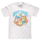 White graphic T-shirt featuring Smurf characters with colorful mushroom artwork and “Just Be Cool” slogan
