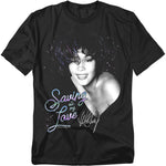 Black T-shirt featuring a black-and-white portrait of Whitney Houston with neon text reading “Saving All My Love” and her signature underneath.