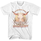 White T-shirt featuring a vintage Willie Nelson design with a steer skull, desert landscape, and “On the Road Again” text.