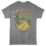 Heather gray T-shirt featuring a vintage Willie Nelson On the Road Again desert highway graphic with western-inspired lettering.