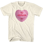 Cream-colored Rocky t-shirt featuring a pink candy heart with the words “Yo Adrian” in red lettering.